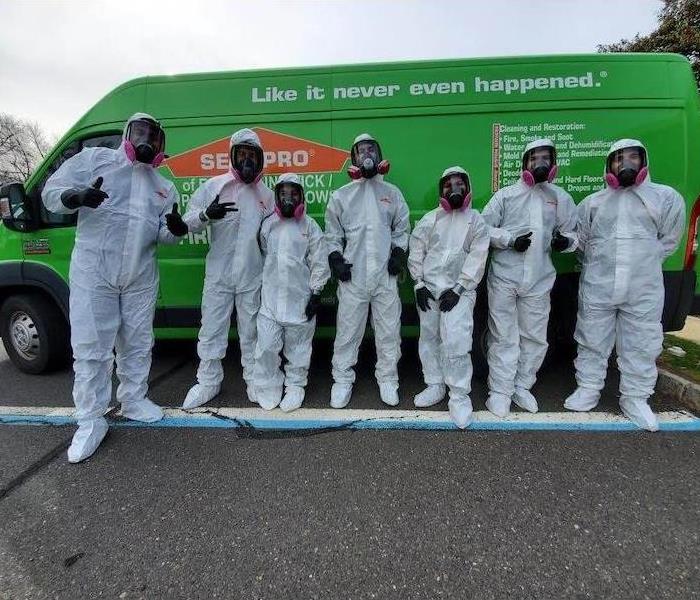 SERVPRO technicians by green van in personal protective equipment