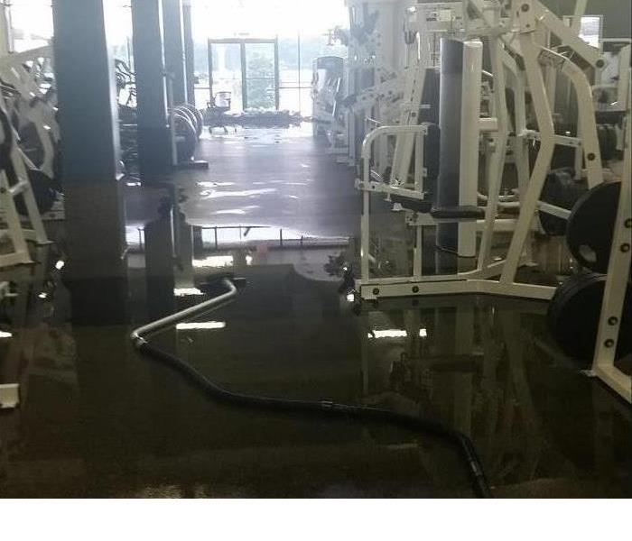 Gym with equipment and standing water on the floor