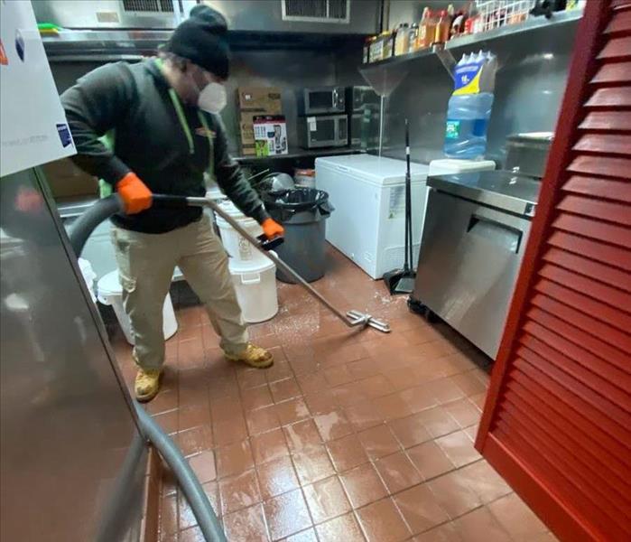 SERVPRO technician with water removal equipment in commercial kitchen