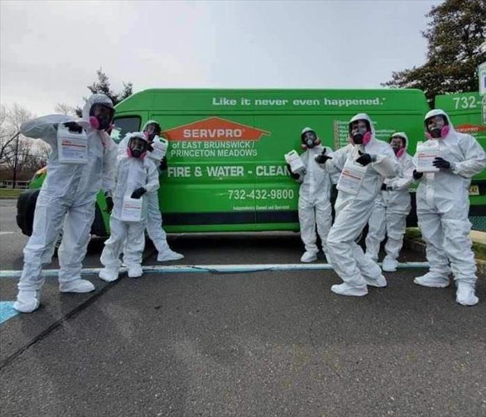 A group of SERVPRO employees standing in front of a van.  